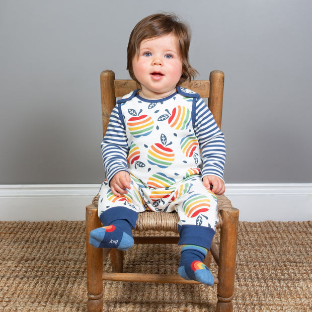 Baby in rainbow apple dungarees