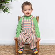 Boy in rainbow ticking dungarees