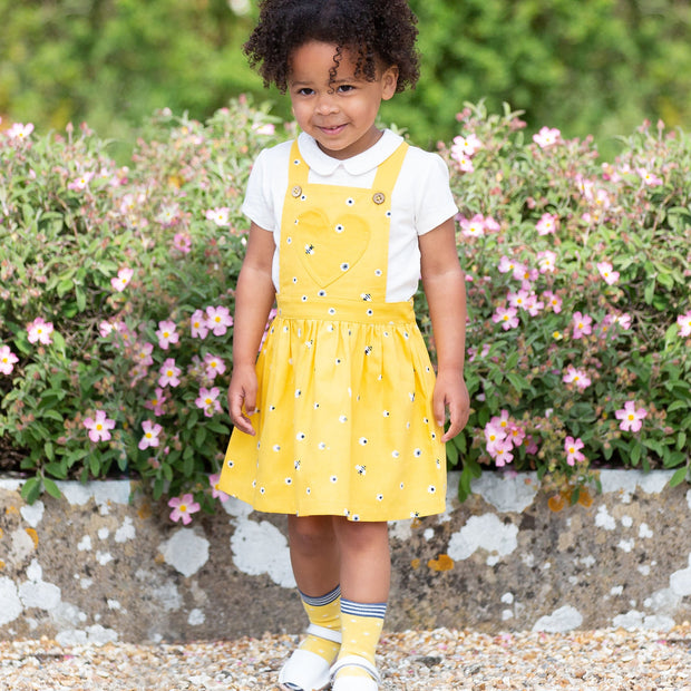 Girl in mini honey bee pinafore